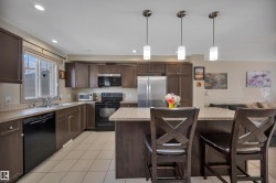 Kitchen featuring dark wood-finish cabinetry, light-toned countertops, and a tile backsplash - 