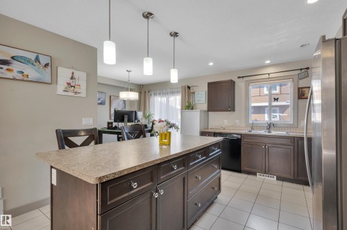 Kitchen featuring a central island with storage, laminate countertops, and tile flooring - 29 1150 Windermere Way, Edmonton, AB 