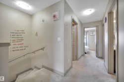 Carpeted staircase with a metal handrail, leading to a carpeted hallway with multiple doorways - 