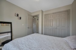 Pendant lighting illuminates this bedroom featuring neutral wall tones, a paneled bifold closet, and a swing door entry - 