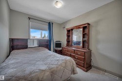 Carpeted room featuring a single window with blinds and blue drapes, light neutral wall paint, and a ceiling-mounted light fixture - 