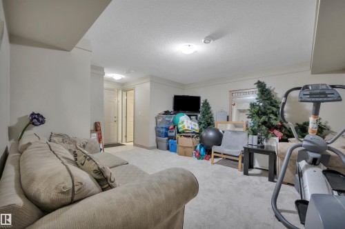 Spacious lower level featuring light-colored carpeting, multiple overhead light fixtures, and a neutral wall palette - 29 1150 Windermere Way, Edmonton, AB 