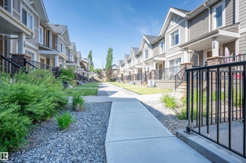 Exterior townhome showcasing horizontal siding, stone accents, and gabled roofs - 29 1150 Windermere Way, Edmonton, AB 