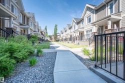 Exterior townhome showcasing horizontal siding, stone accents, and gabled roofs - 