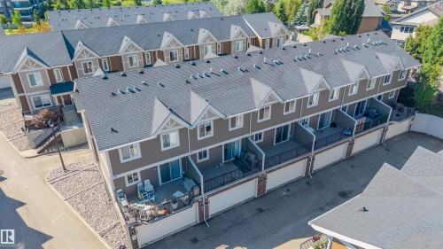 Multi-level townhome exterior featuring an attached garage, private balcony, and dormer windows - 29 1150 Windermere Way, Edmonton, AB 