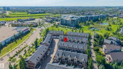 Aerial perspective showcasing a community of townhome-style residences with dark roofs and light-colored siding - 