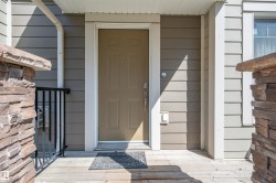 Entryway featuring a wood-finish porch, stone veneer accents, and horizontal siding - 