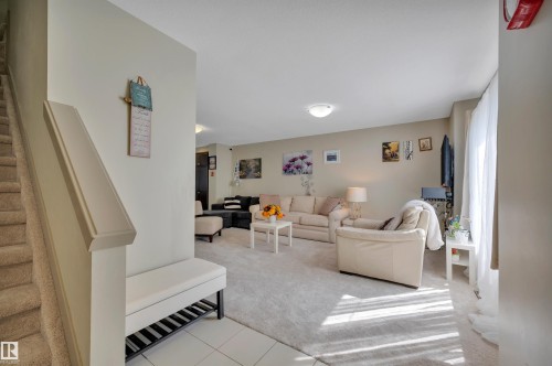 Carpeted staircase with a prominent white handrail and a neutral wall - 29 1150 Windermere Way, Edmonton, AB 
