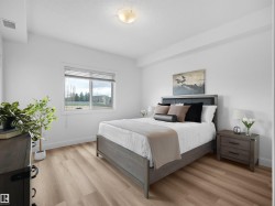 Spacious room featuring light wood-finish flooring, white walls, and a large window with horizontal blinds - 