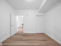 Wood-finish flooring with white baseboards throughout the space - 