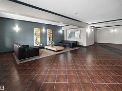 Spacious common area featuring large format terracotta-toned floor tiles and recessed wall sconces - 