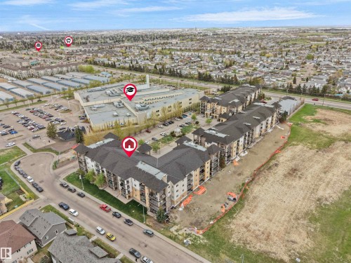 Aerial perspective showcasing a multi-story residential complex with balconies and a dark shingle roof - 104 14612 125 Street, Edmonton, AB 
