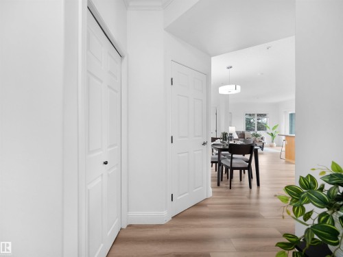 Entryway featuring light wood-finish flooring, white walls, and bright overhead lighting - 104 14612 125 Street, Edmonton, AB 