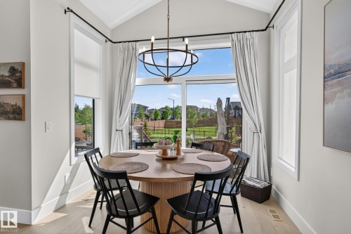 Dining area with a vaulted ceiling and a contemporary chandelier - 14 Jane Point(E), St. Albert, AB 