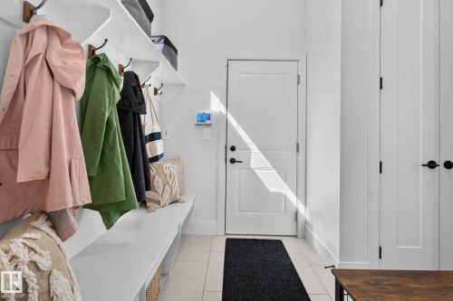 Entryway featuring built-in white shelving, integrated bench seating, and wall-mounted coat hooks - 14 Jane Point(E), St. Albert, AB 