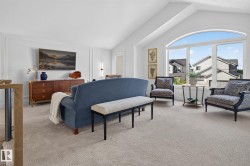 Spacious upper-level room featuring a vaulted ceiling and a large arched window - 