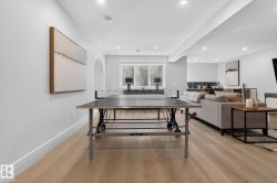 Spacious recreation room featuring wood-finish flooring and recessed lighting - 