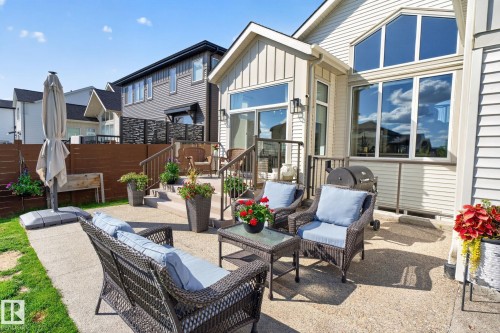 Spacious concrete patio and tiered deck with dark wood railing and balusters - 14 Jane Point(E), St. Albert, AB 