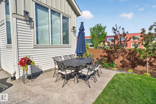 Private concrete patio featuring a manicured lawn and mature trees - 14 Jane Point(E), St. Albert, AB 