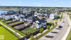 Aerial view of a residential neighborhood featuring homes with dark roofs and light-colored siding - 