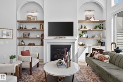 Living area featuring a fireplace with a white mantel, built-in shelving, arched wall niches, and wood-finish floating shelves with integrated lighting - 
