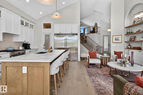 Open-concept living space featuring a gourmet kitchen with a large island, stainless steel appliances, and white cabinetry - 14 Jane Point(E), St. Albert, AB 