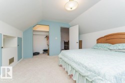 Carpeted room featuring sloped ceilings and light blue accent walls - 