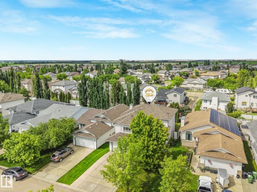 Single-family home featuring a brown shingle roof, solar panel array, attached front-facing garage, and a concrete driveway - 98 Bridgeport Wynd, Leduc, AB 