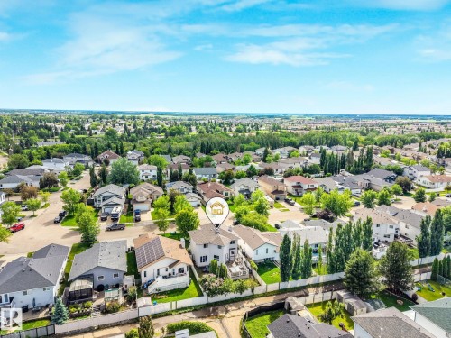 Aerial perspective showcasing a residential neighborhood with varied home styles and mature landscaping - 98 Bridgeport Wynd, Leduc, AB 
