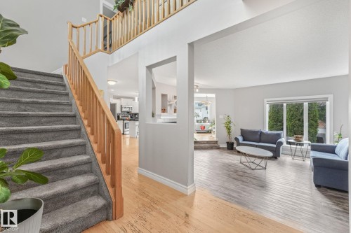 Split-level entry with carpeted stairs and natural wood banisters - 98 Bridgeport Wynd, Leduc, AB 