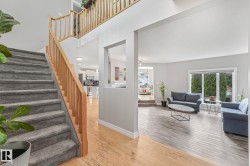 Split-level entry with carpeted stairs and natural wood banisters - 
