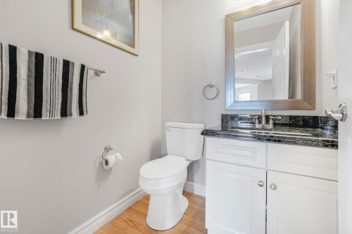Bathroom featuring a white vanity with dark countertop, undermount sink, and brushed nickel fixtures - 98 Bridgeport Wynd, Leduc, AB 