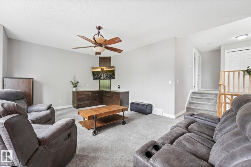 Spacious living area featuring light gray walls and plush gray carpeting - 98 Bridgeport Wynd, Leduc, AB 