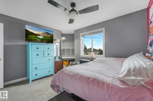 Carpeted room with a ceiling fan, a window, and grey walls - 98 Bridgeport Wynd, Leduc, AB 