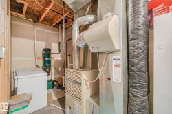 Utility area featuring a forced-air furnace, humidifier, exposed ceiling joists, and a central vacuum system - 