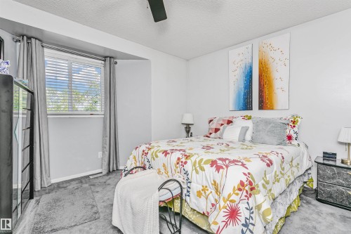 Carpeted bedroom with a window featuring horizontal blinds and drapery - 1612 80A Street, Edmonton, AB 
