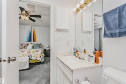 Bathroom vanity with integrated sink, white cabinetry, and a framed mirror - 