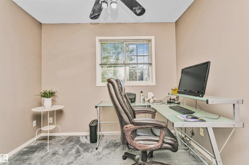 Bright interior room featuring a window with blinds, neutral wall paint, and textured flooring - 1612 80A Street, Edmonton, AB 