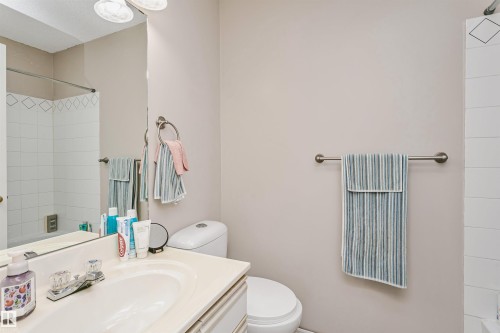 Bathroom featuring a light-toned vanity with an integrated sink and clear knob fixtures - 1612 80A Street, Edmonton, AB 