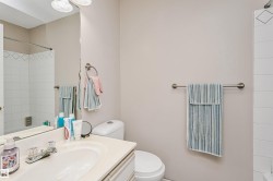 Bathroom featuring a light-toned vanity with an integrated sink and clear knob fixtures - 