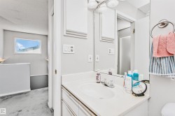 Bathroom vanity with an integrated sink, polished chrome faucet, and a large wall-mounted mirror - 