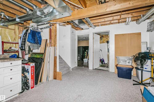 Carpeted floor area with an exposed wood joist ceiling and visible ductwork - 1612 80A Street, Edmonton, AB 