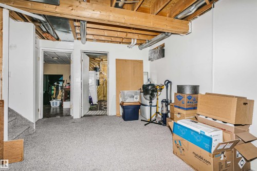 Utility space featuring exposed ceiling joists and ductwork, carpeted flooring, and white painted walls - 1612 80A Street, Edmonton, AB 