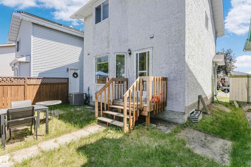 Exterior stucco finish with a ground-level deck featuring wood railings and steps - 1612 80A Street, Edmonton, AB 