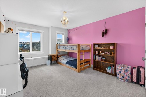 Bright room featuring a large window with a built-in window seat, plush carpet, and a decorative ceiling fixture - 30 Rosewood Way, St. Albert, AB 