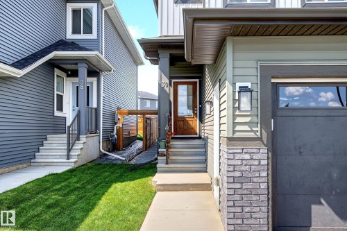 Modern façade featuring light green siding with dark trim accents - 30 Rosewood Way, St. Albert, AB 