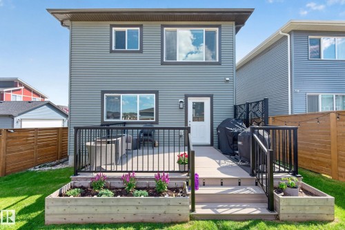 Exterior featuring a multi-level deck, wood-finish privacy fence, and a manicured lawn - 30 Rosewood Way, St. Albert, AB 