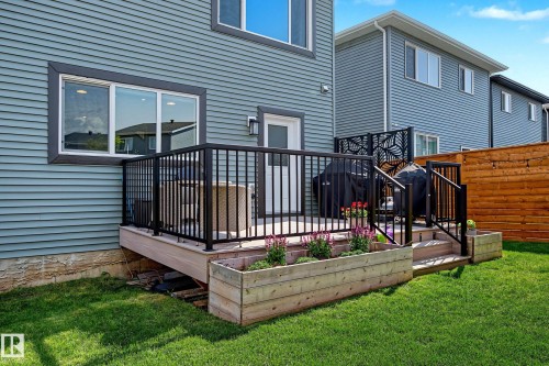 Raised deck with black aluminum railings, featuring a privacy screen with a leaf motif - 30 Rosewood Way, St. Albert, AB 