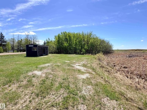 Compact structure with dark siding and a prominent glass entry, situated on a grassy lot - 50 Ave. 52 St., Rural Westlock County, AB 