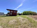 Modern detached structure with wood-finish siding, a sloped roof, and a wood-slat deck - 50 Ave. 52 St., Rural Westlock County, AB 